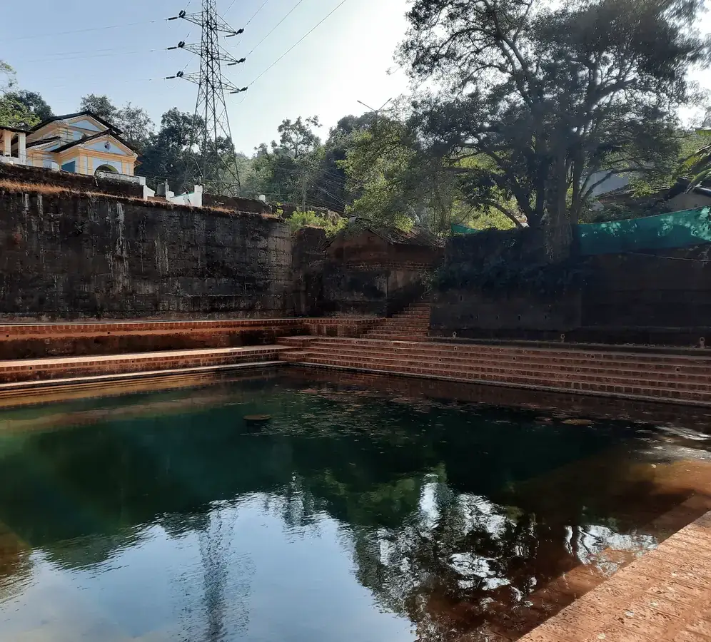The temple lake, its laterite steps descending into still water