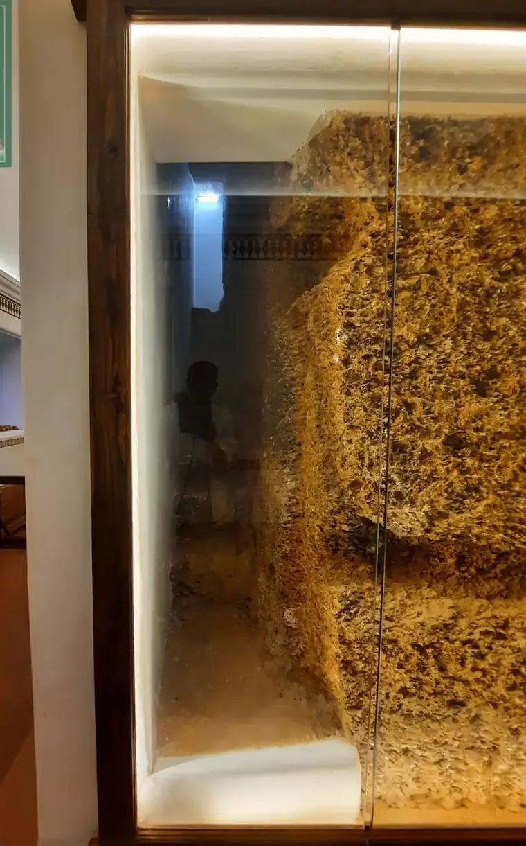 Exposed laterite of a concealed passage, lit behind glass